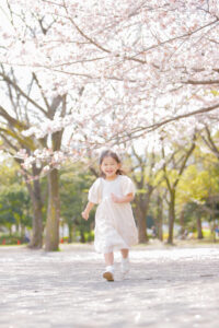 桜をバックに走る女の子